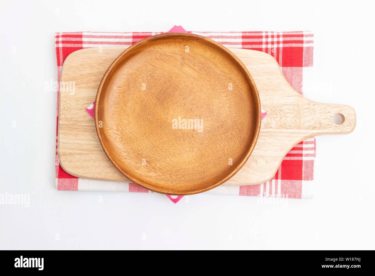 Vuoto piatto di legno e tagliere di legno sul rosso a scacchi tessili e sfondo bianco : vista superiore Foto Stock