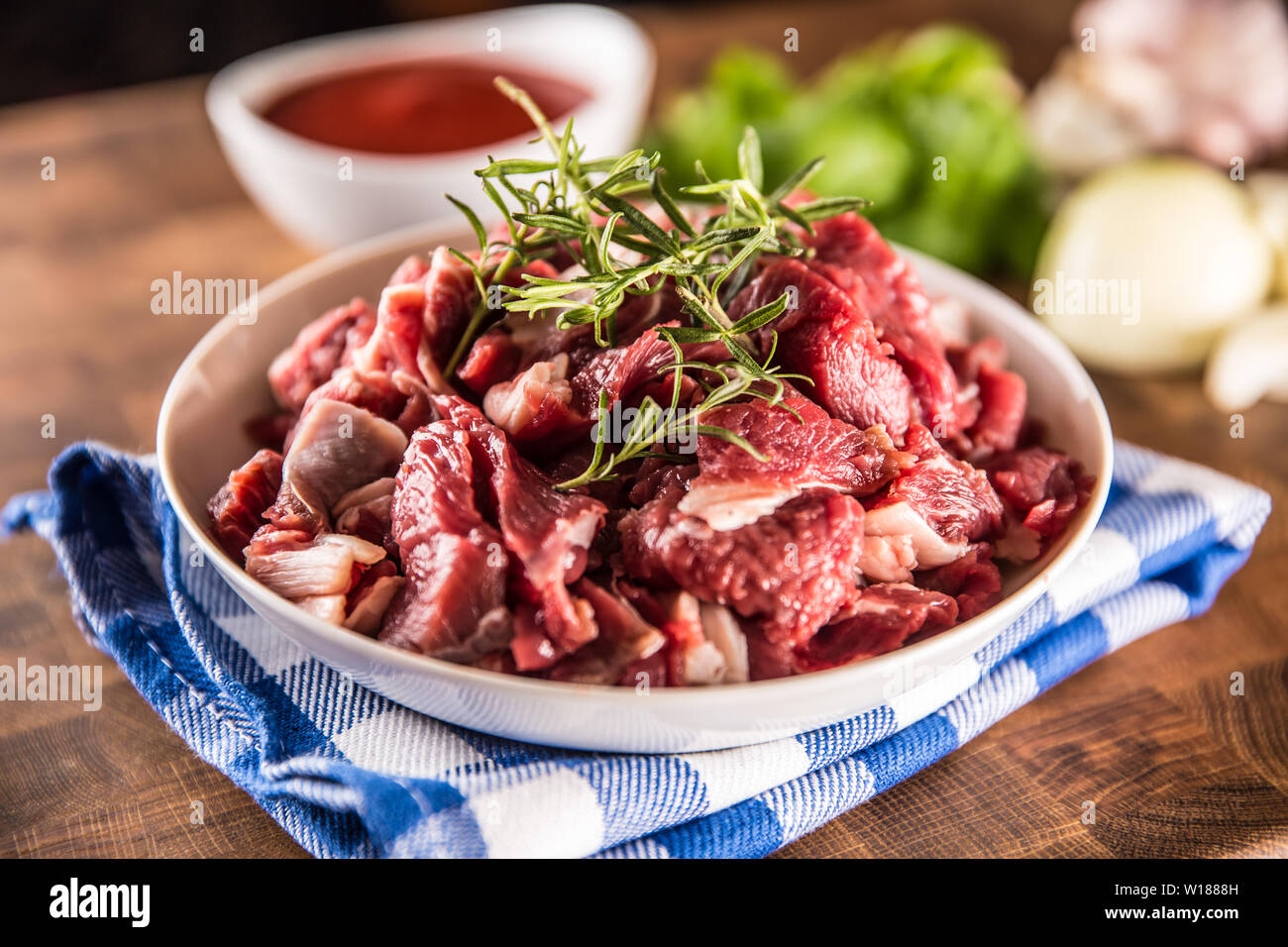 Materie carni bovine pezzi con rosmarino in vaso su butcher board Foto Stock