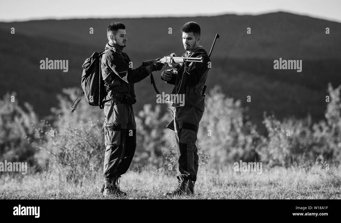 Amicizia di uomini cacciatori. Uniforme militare di moda. Forze armate. Il camuffamento. Abilità di caccia e di apparecchiature di arma. Come ruotare la caccia in hobby. I cacciatori di uomo con un fucile pistola. Boot camp. sulla caccia. Foto Stock