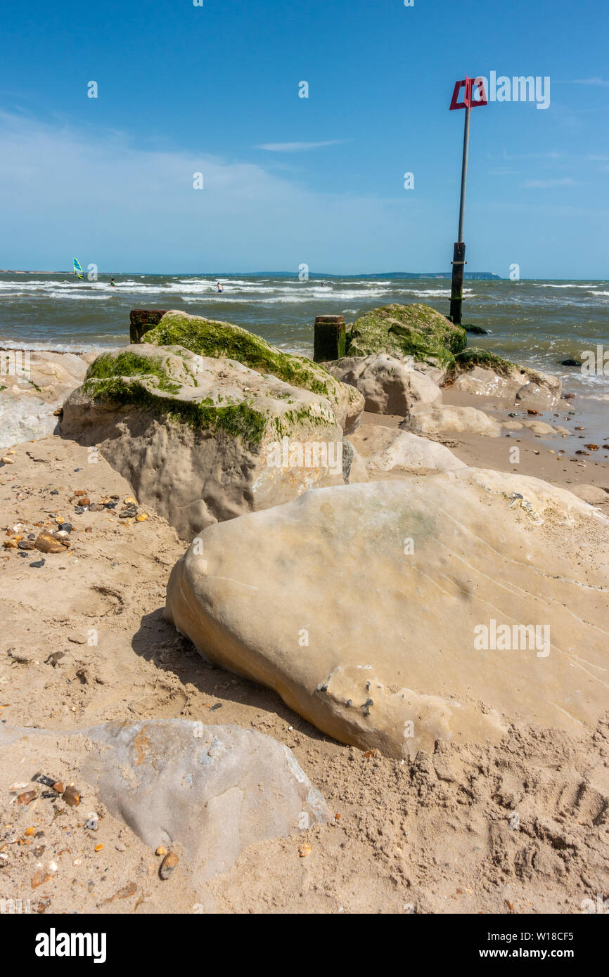 Massi su Avon spiaggia a Mudeford, Christchurch in Dorset, Regno Unito , formano un groyne per combattere la deriva costiere e proteggere la spiaggia. Foto Stock