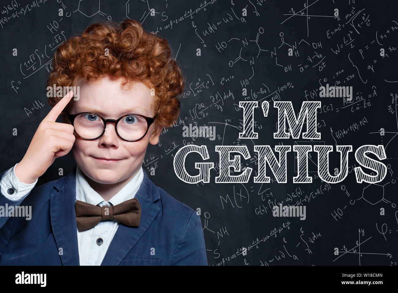 Genius bambino sulla lavagna sfondo con la scienza e la matematica di formule Foto Stock