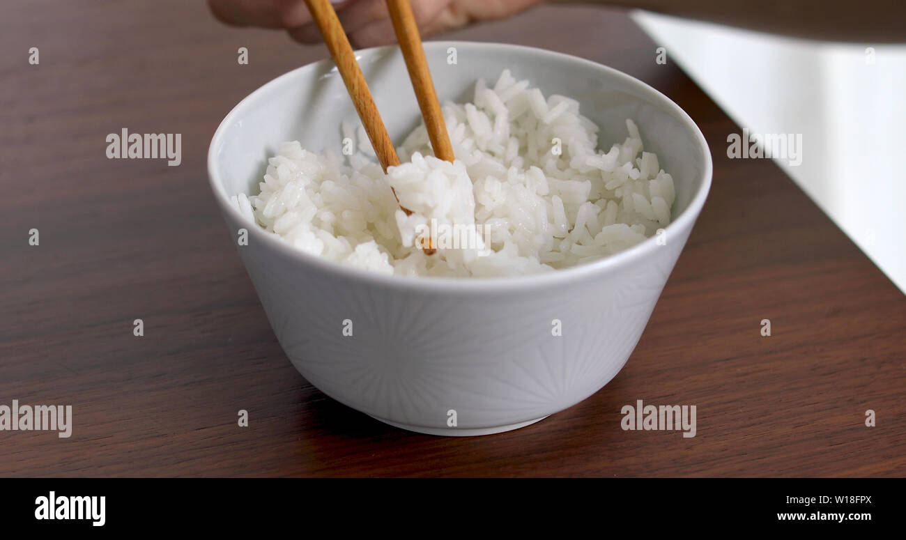Primo piano della donna a mangiare riso dalla vaschetta Foto Stock