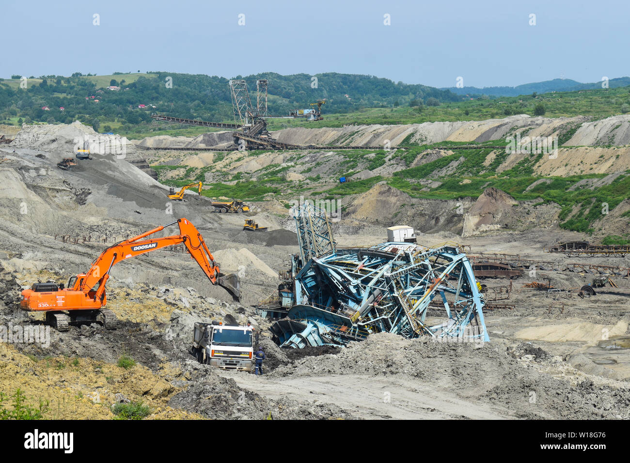 Miniera di carbone incidente con una pesante macchina di estrazione all'interno del carbone di sfruttamento. Il grande escavatore è crollato nella fossa aperta. Posto di lavoro pericolose - B Foto Stock