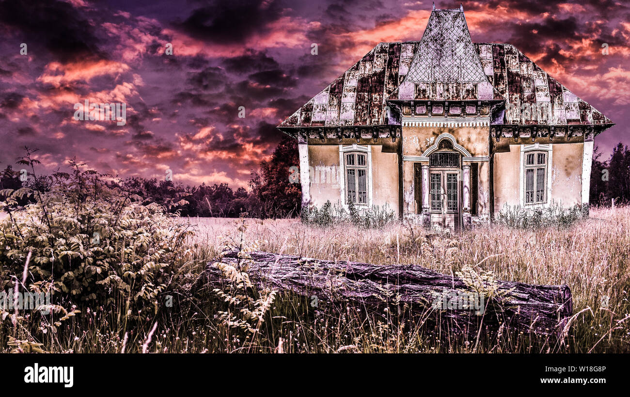 Haunted vecchia casa in una drammatica atmosfera horror con il fuoco del cielo. Creepy tramonto sulla antica dimora spaventosa in una scena di Halloween. Foto Stock
