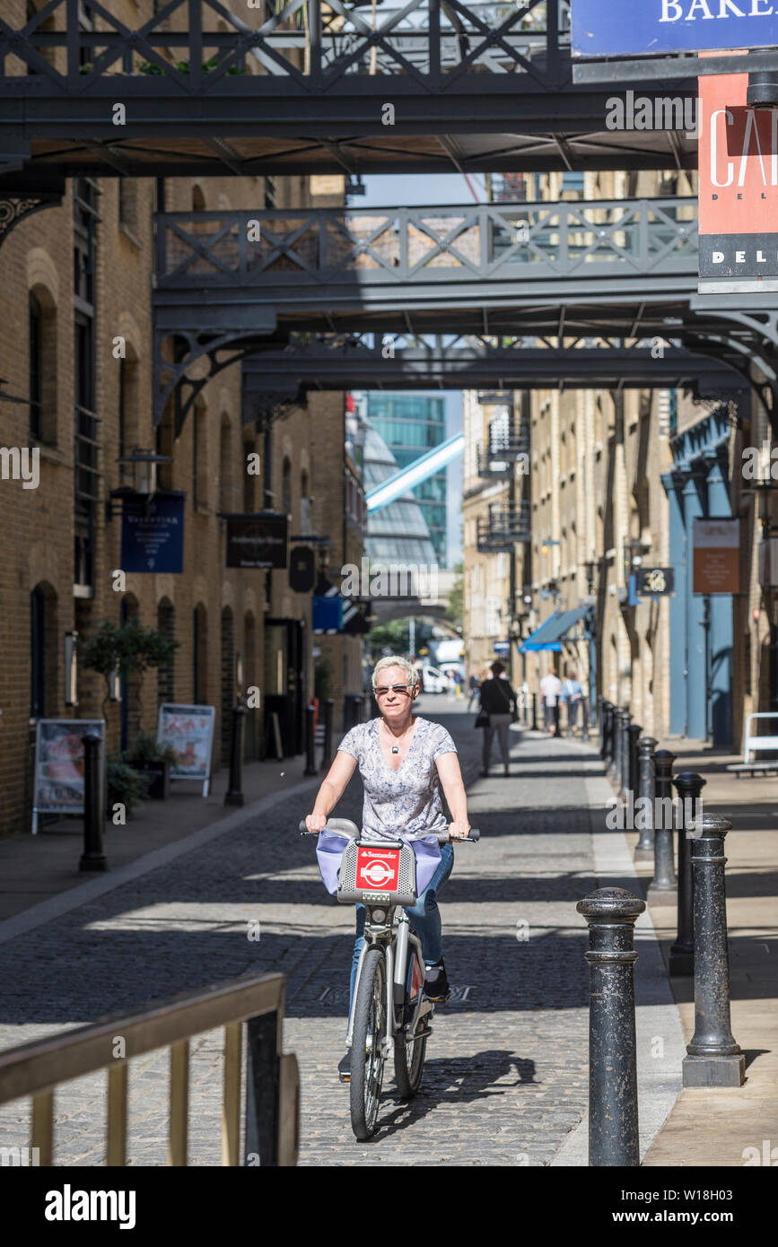 Un ciclista in sella a una Boris bici giù Shad Thames Foto Stock