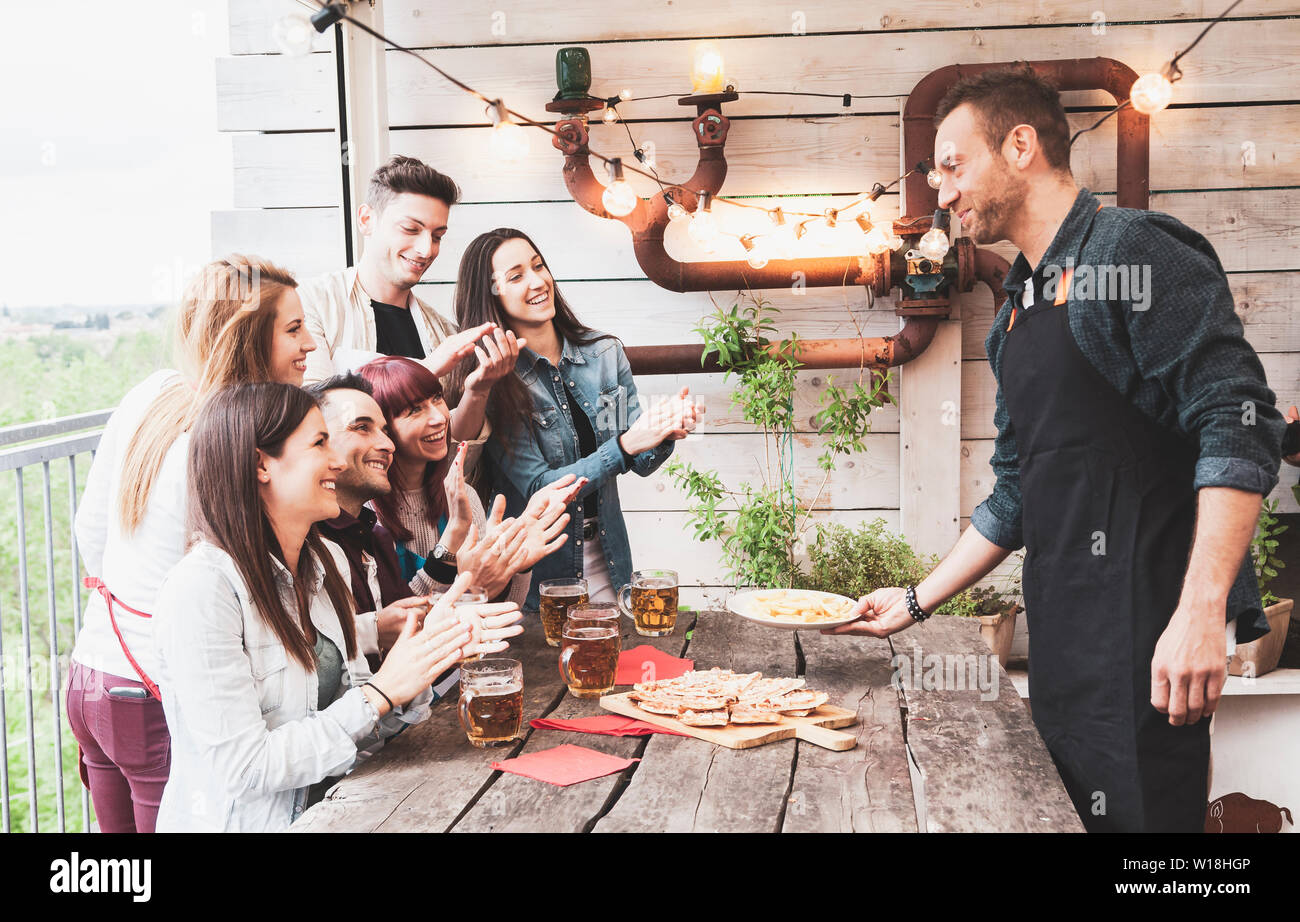 Felice gruppo di amici a bere birra e mangiare la pizza al bar birreria ristorante. concetto con i giovani avendo divertimento genuino Foto Stock