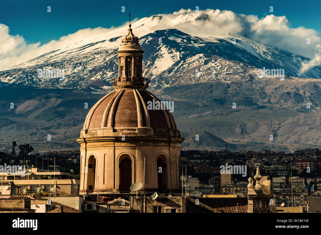 La cupola del Duomo di Catania sullo sfondo del vulcano Etna in neve.La vista della città di Catania con la vista del vulcano Etna, Sicilia Foto Stock