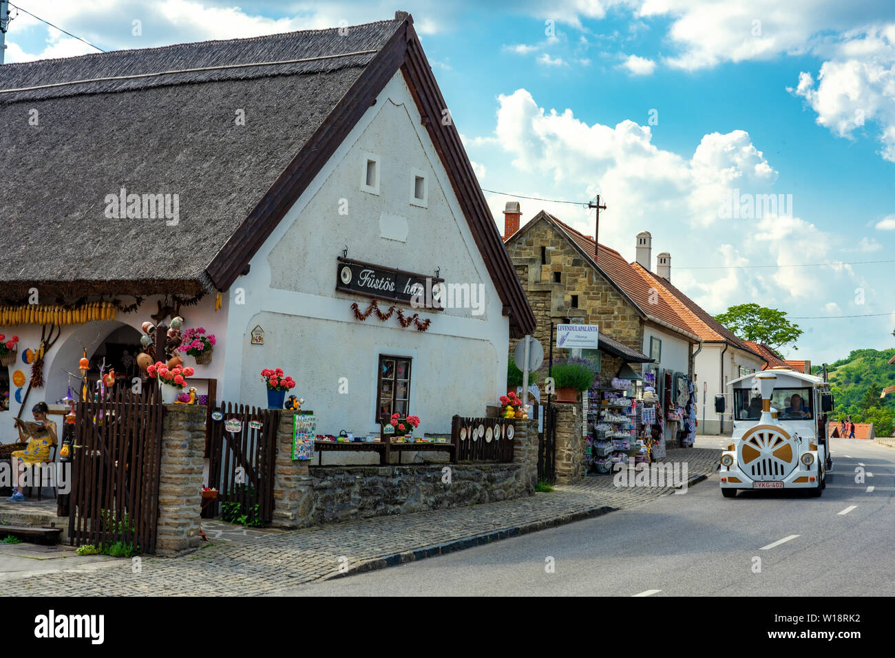 Tihany, Ungheria - 06.10.2019 : folkloristico di vecchie case souvenir shop in Tihany con la piccola città treno turistico sulla riva settentrionale del Lago Balaton Foto Stock