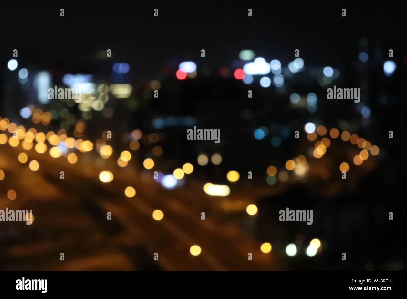 Luci della città offuscata la sfocatura bokeh di fondo. Città di sfocatura dello sfondo bokeh di fondo. Città nero scape background. Foto Stock