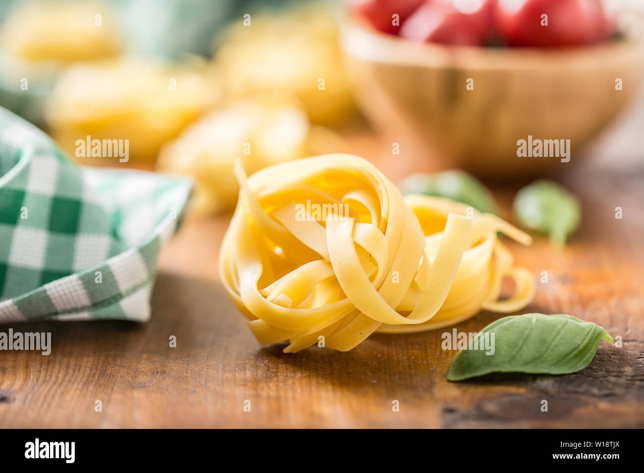 La pasta italiana Le tagliatelle su tavola con basilico e pomodori Foto Stock