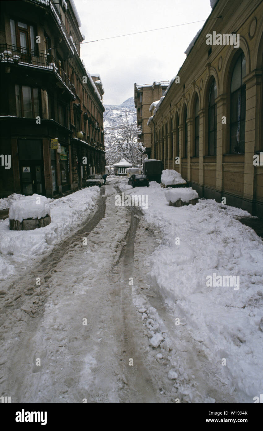 Il 28 marzo 1993 durante l'assedio di Sarajevo: la vista a sud verso il basso una snowbound Gajev Street nel centro della citta'. Il assediava forze della Republika Srpska occupano le colline in background. Foto Stock