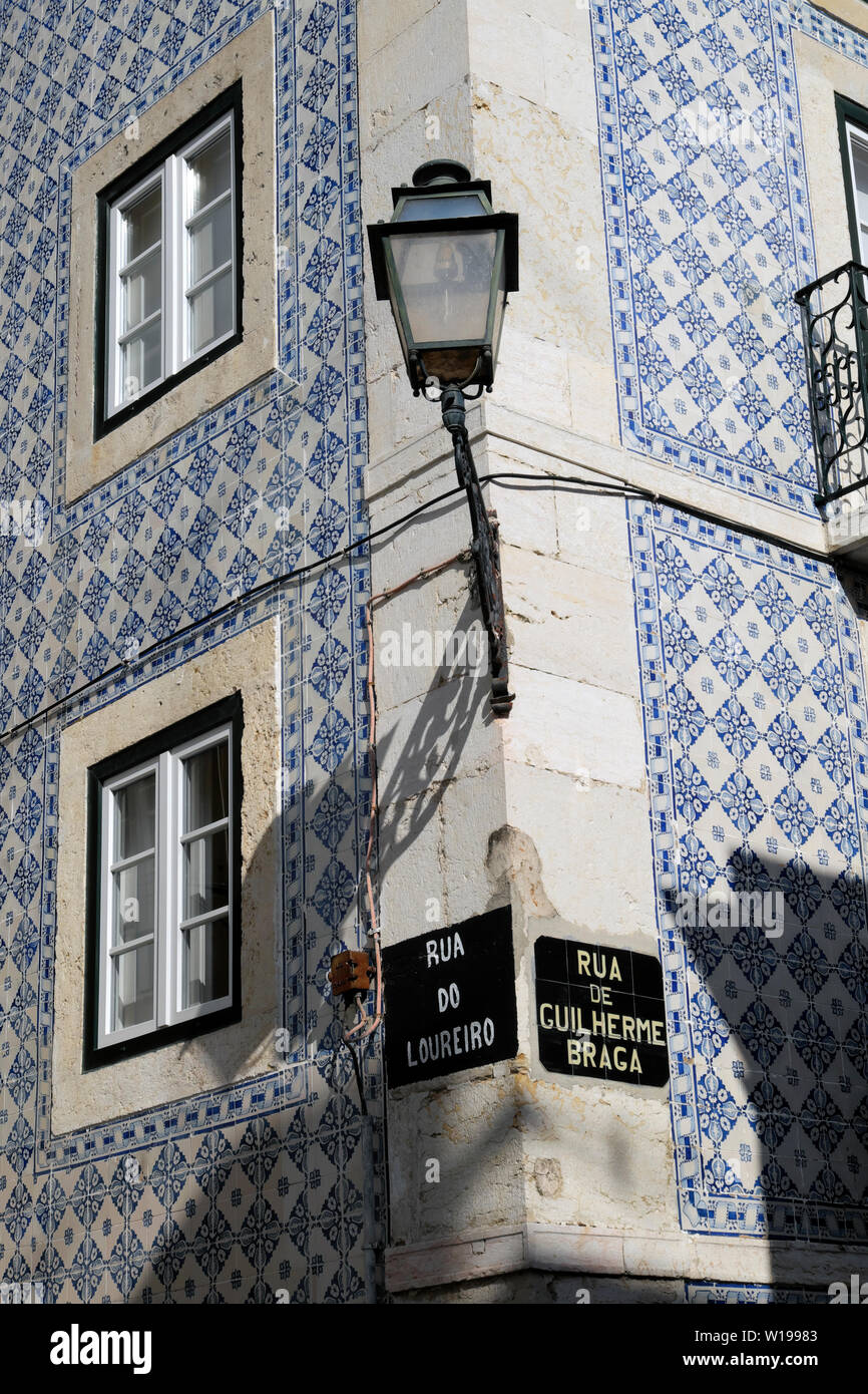 Vista verticale del centro storico di lampada a gas su blu edificio rivestito di piastrelle su un angolo e il portoghese via segni in Alfama Lisbona Portogallo Europa KATHY DEWITT Foto Stock