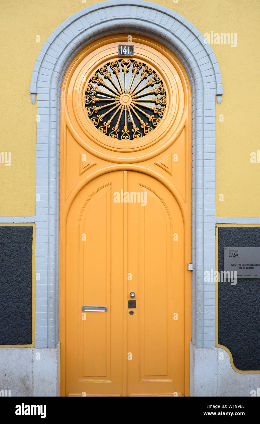 Verniciato giallo porta con ritaglio circolare design nel Bairro Alto Lisbona Portogallo Europa KATHY DEWITT Foto Stock