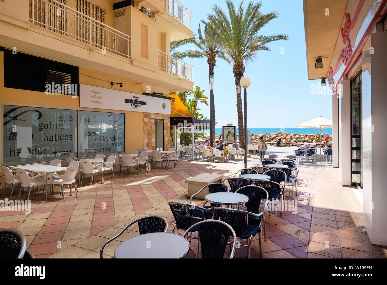 Torrevieja, Spagna - 16 Maggio 2019: affascinante strada vuota con tavoli e sedie open-air all'aperto cafe e ristoranti vista sul Mar Mediterraneo, Spagna Foto Stock