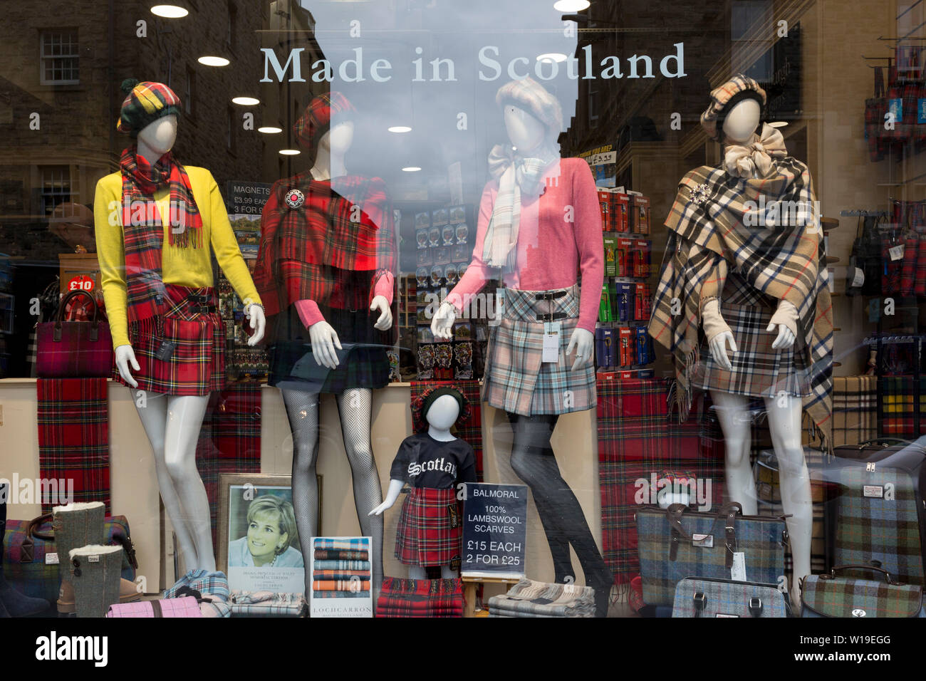 Tartan kilts e nazionale tessuti scozzesi in vendita nella vetrina di un negozio di souvenir sul Royal Mile di Edimburgo, il 25 giugno 2019, a Edimburgo, Scozia. Foto Stock