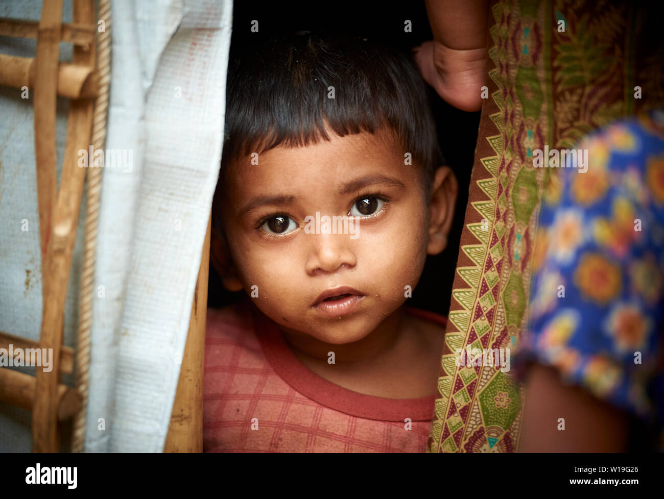 Ragazzo che guarda al di fuori del riparo in Kutupalong Rohingya Refugee Camp, Bangladesh Foto Stock