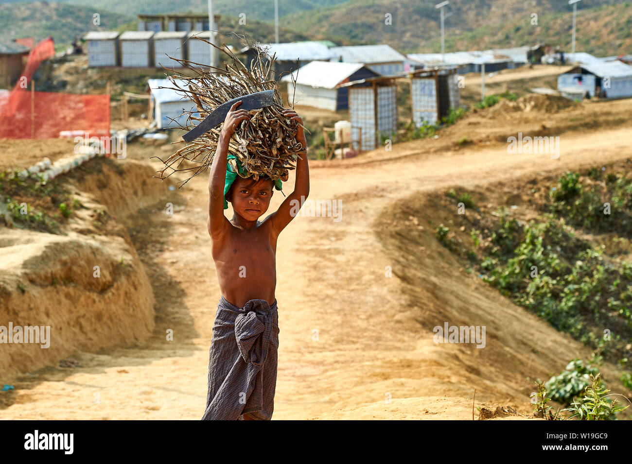 Ragazzo che trasportano legna da ardere in Rohingya Refugee Camp Kutupalong, Bangladesh Foto Stock