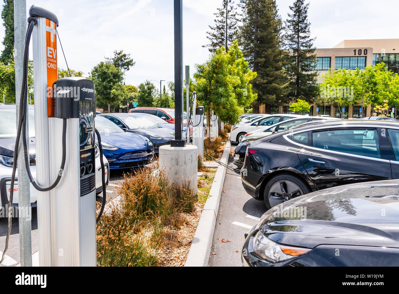 Giugno 24, 2019 Mountain View / CA / STATI UNITI D'AMERICA - varie marche di veicoli elettrici e ibridi parcheggiata in una trafficata Stazione di carica nella parte sud di San Francisco Bay a Foto Stock