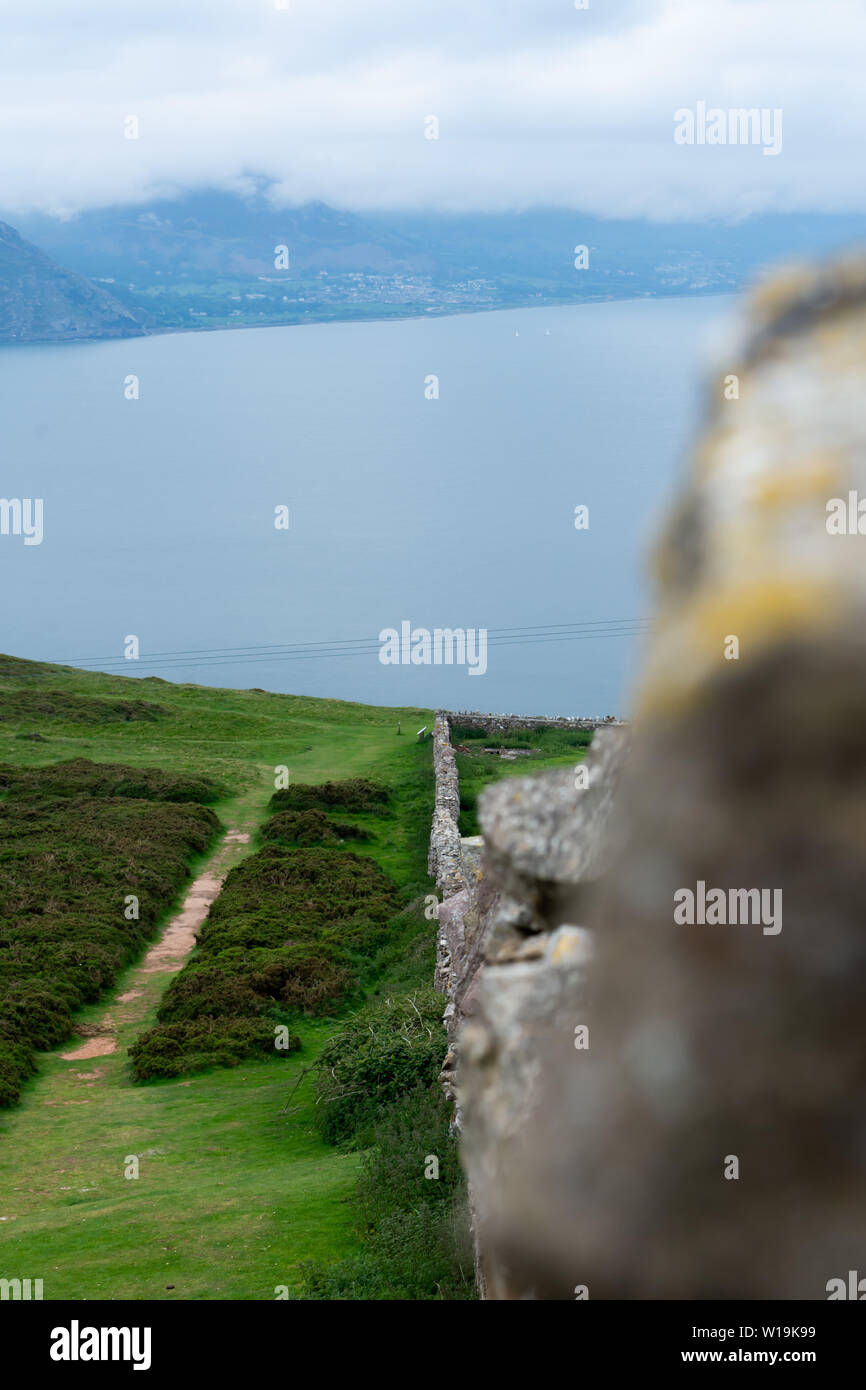 Guardando lungo un antico muro di pietra sulla sommità del Great Orme di Llandudno. Svettante su St Georges canale. Foto Stock