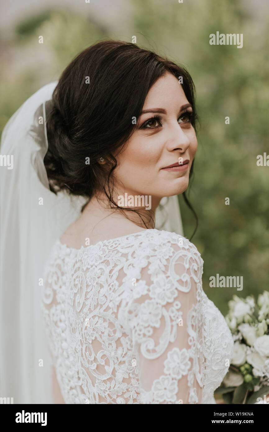 Sposa il giorno delle nozze. Ritratto di giovane sposa sorridente indossando lacey elegante abito da sposa e il velo. Foto Stock
