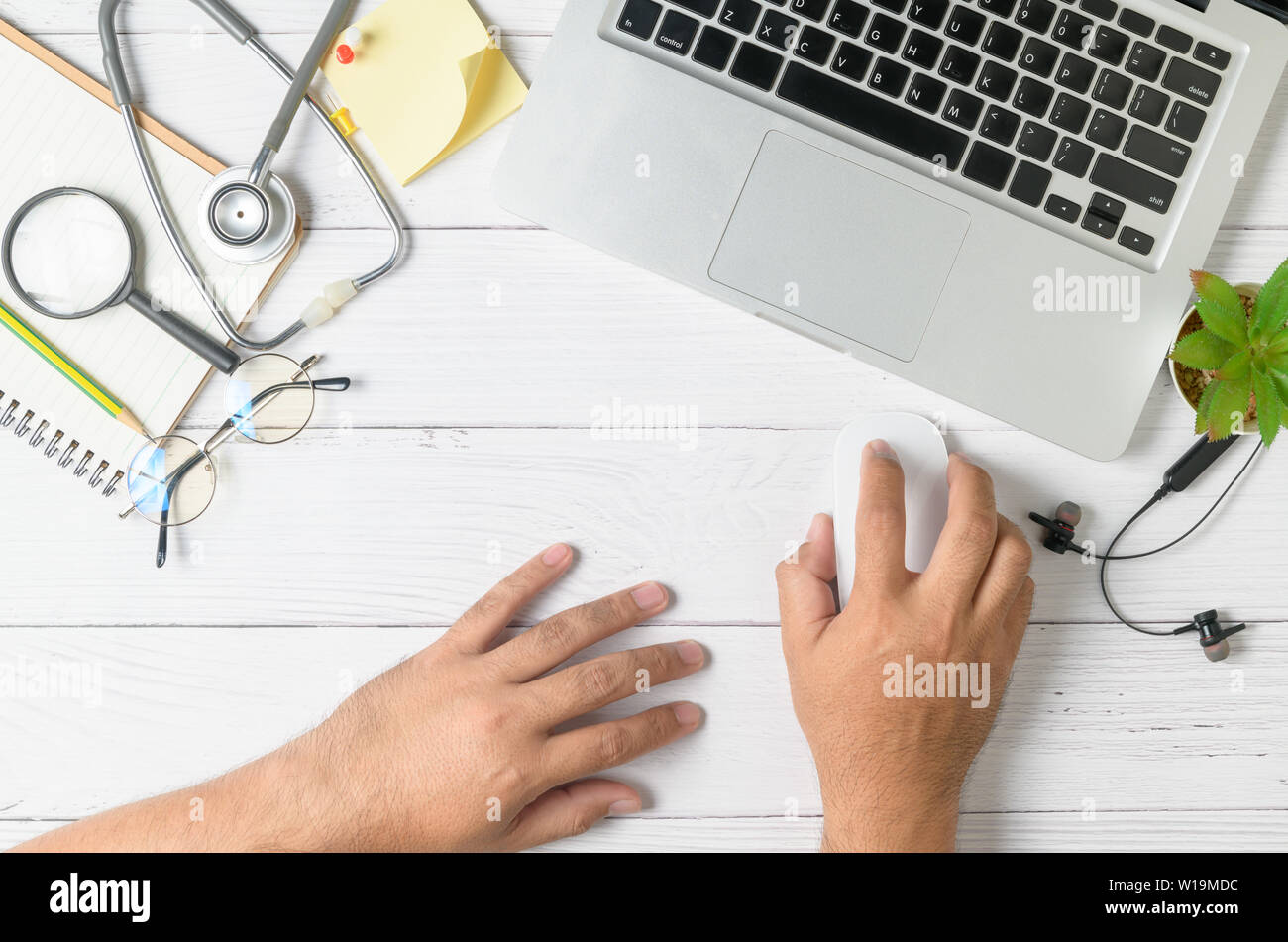 Medico che lavorano in ufficio e scrivania con computer portatile e attrezzature mediche sulla tabella, vista dall'alto Foto Stock