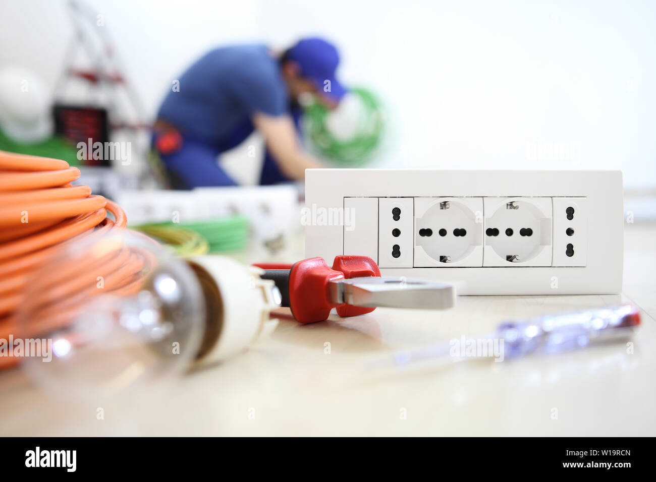 Elettricista e lavorare con le apparecchiature elettriche in primo piano, lampadina, strumenti e socket, circuiti elettrici, cablaggio elettrico Foto Stock