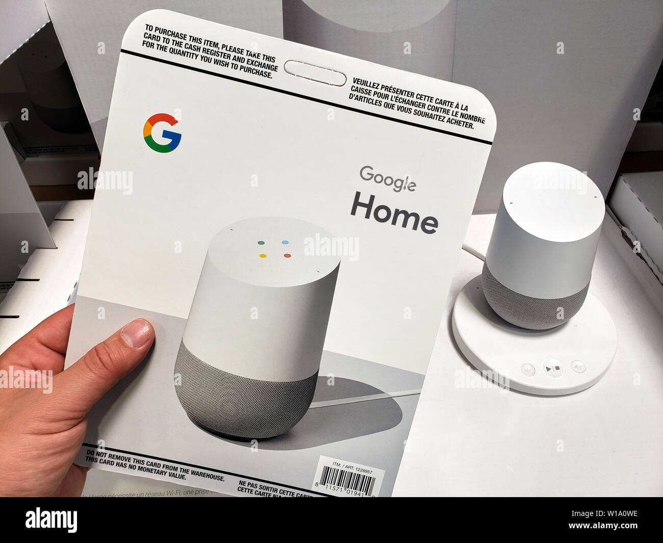 MONTREAL, Canada - 20 giugno 2019: Una mano che tiene la Costco cacardboard scheda di vendita con la Home page di Google. Home page di Google è un altoparlante e di un Assistente vocale. Foto Stock
