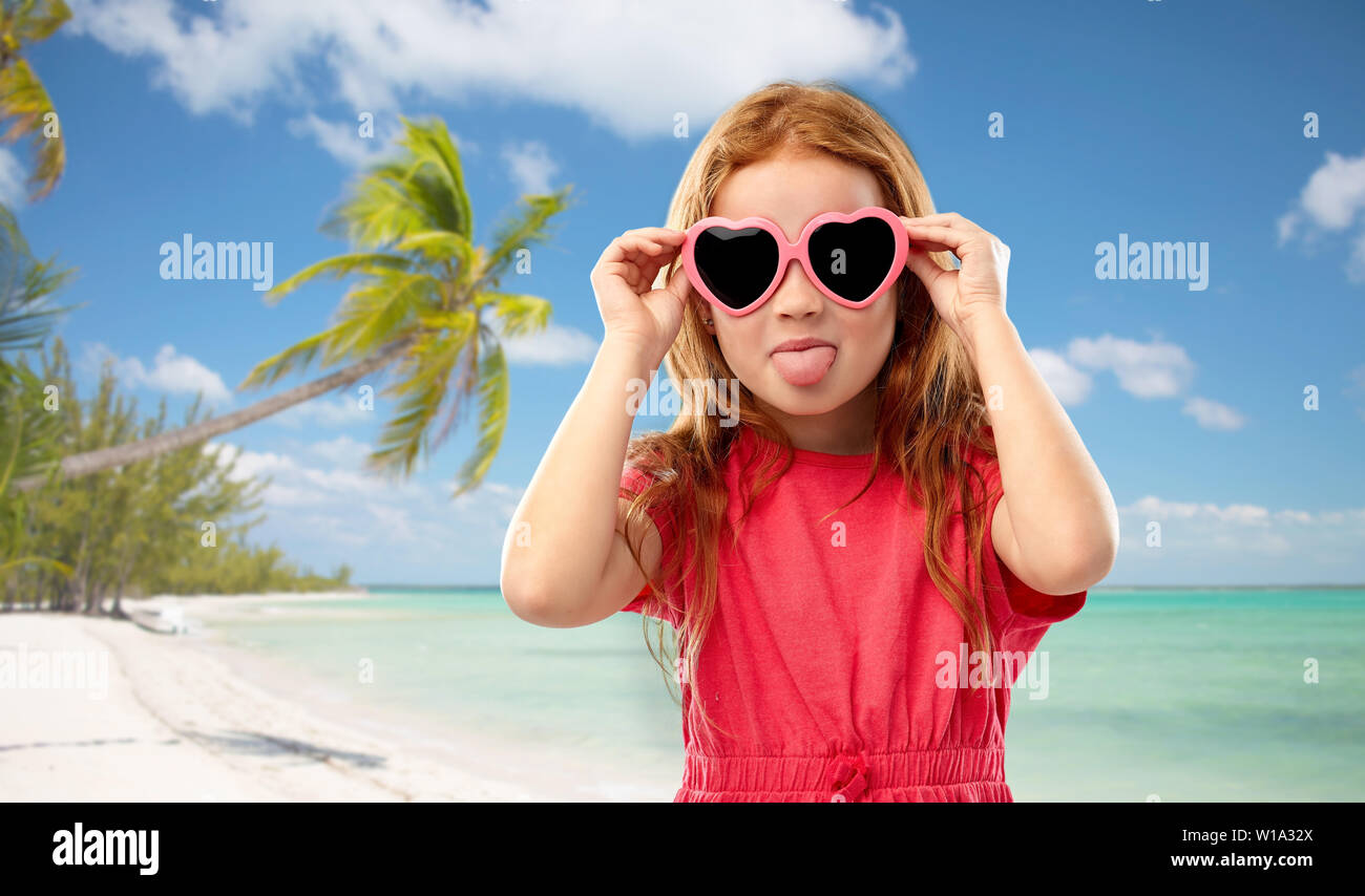 Redhead girl in a forma di cuore ad occhiali da sole sulla spiaggia Foto  stock - Alamy