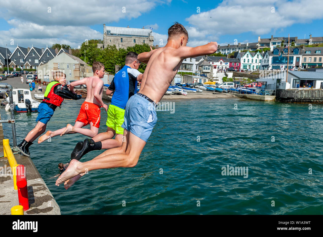 Baltimore, West Cork, Irlanda. 1 Luglio, 2019. Come temperature hit tardo teens su una bella giornata di sole, i turisti e la gente del posto ha avuto la possibilità di rinfrescarvi nell'acqua. Un gruppo di ragazzi ha trascorso il pomeriggio saltando nel porto. Credito: Andy Gibson/Alamy Live News. Foto Stock