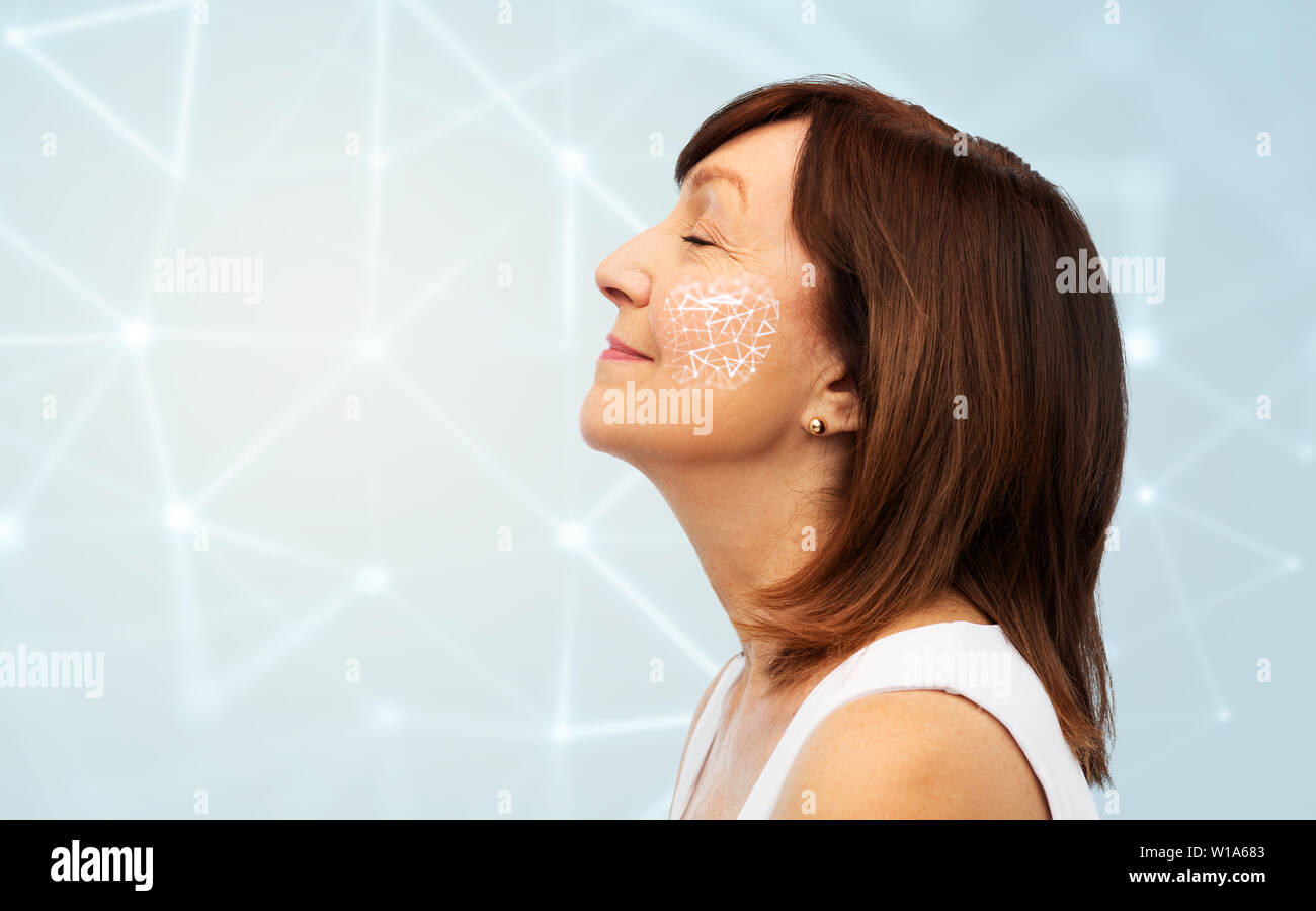 Donna senior con bassa poli griglia sulla sua guancia Foto Stock