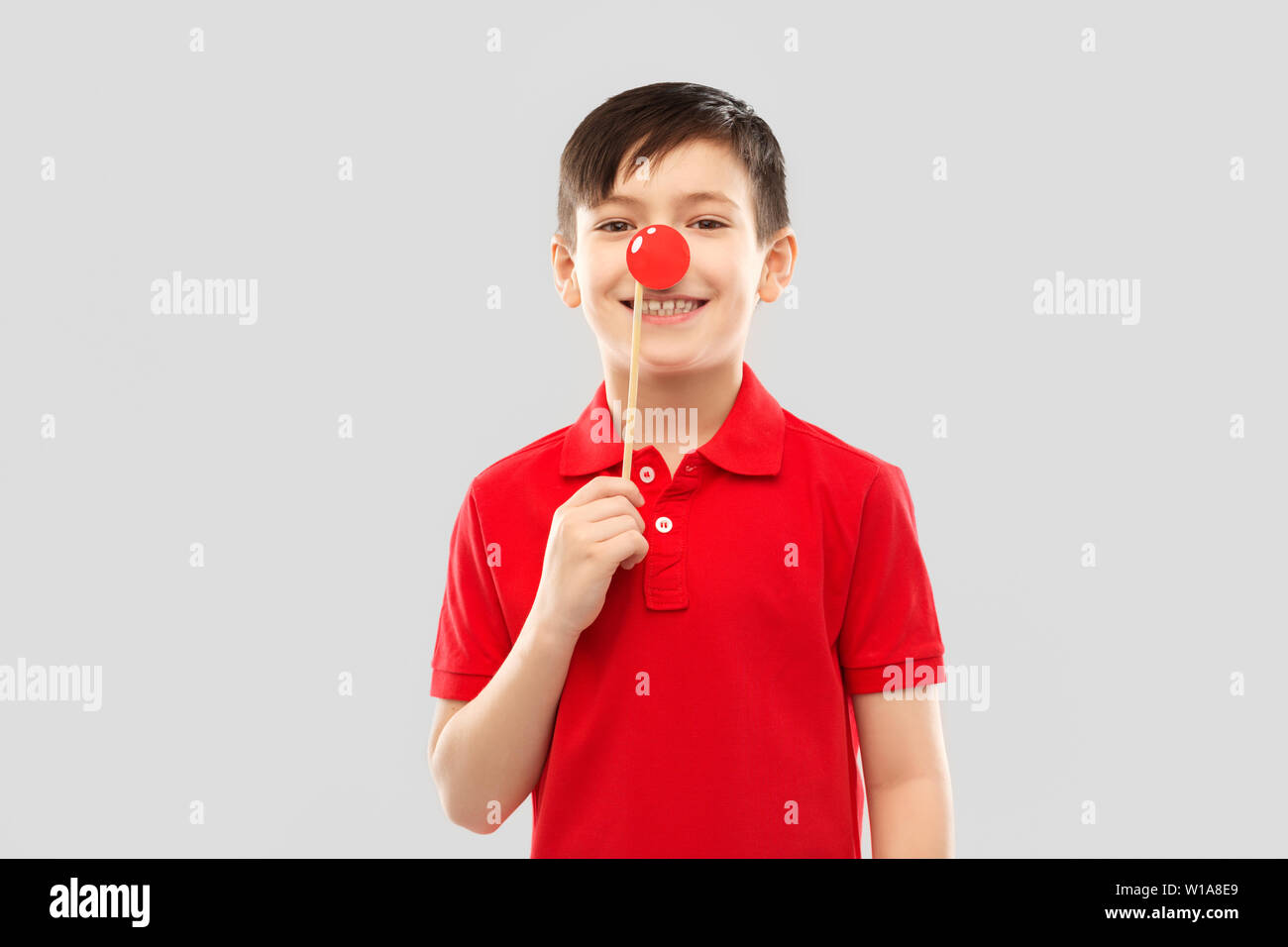 Ragazzo sorridente con red clown naso parte prop Foto Stock