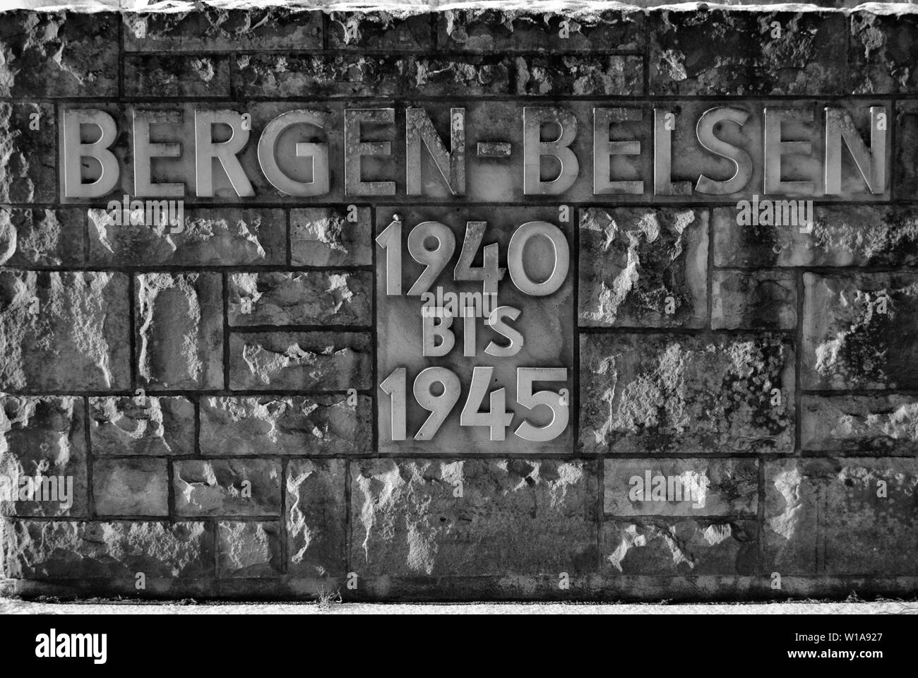 Il muro di pietra all'ingresso a Bergen Belsen Campo di Concentramento con le date quando era in uso Foto Stock