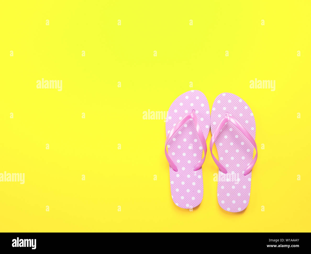 Top visualizza immagine di rosa flip flop su sfondo giallo. Estate trevel e concetto di vacanza Foto Stock