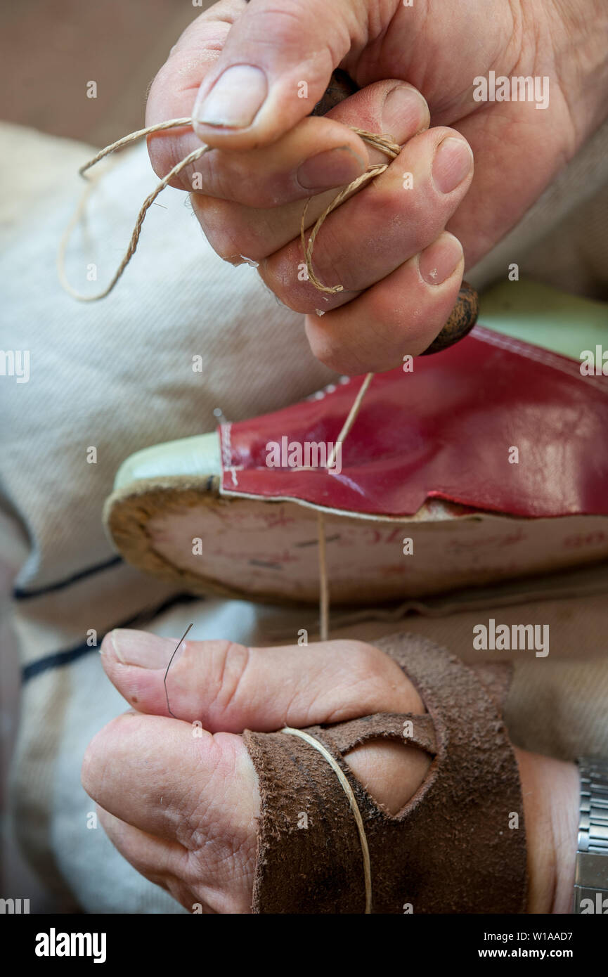 Calzolaio cuce una calzatura craftily, con spago. Foto Stock