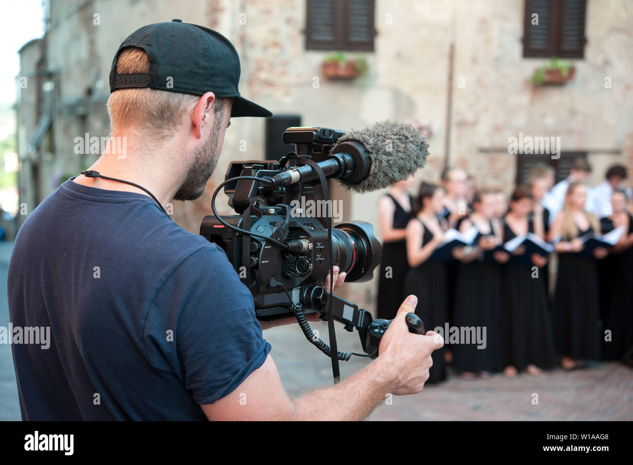 Cameraman cattura video e audio professionali del whit della videocamera, durante una piscina pubblica di musica live performance. Foto Stock