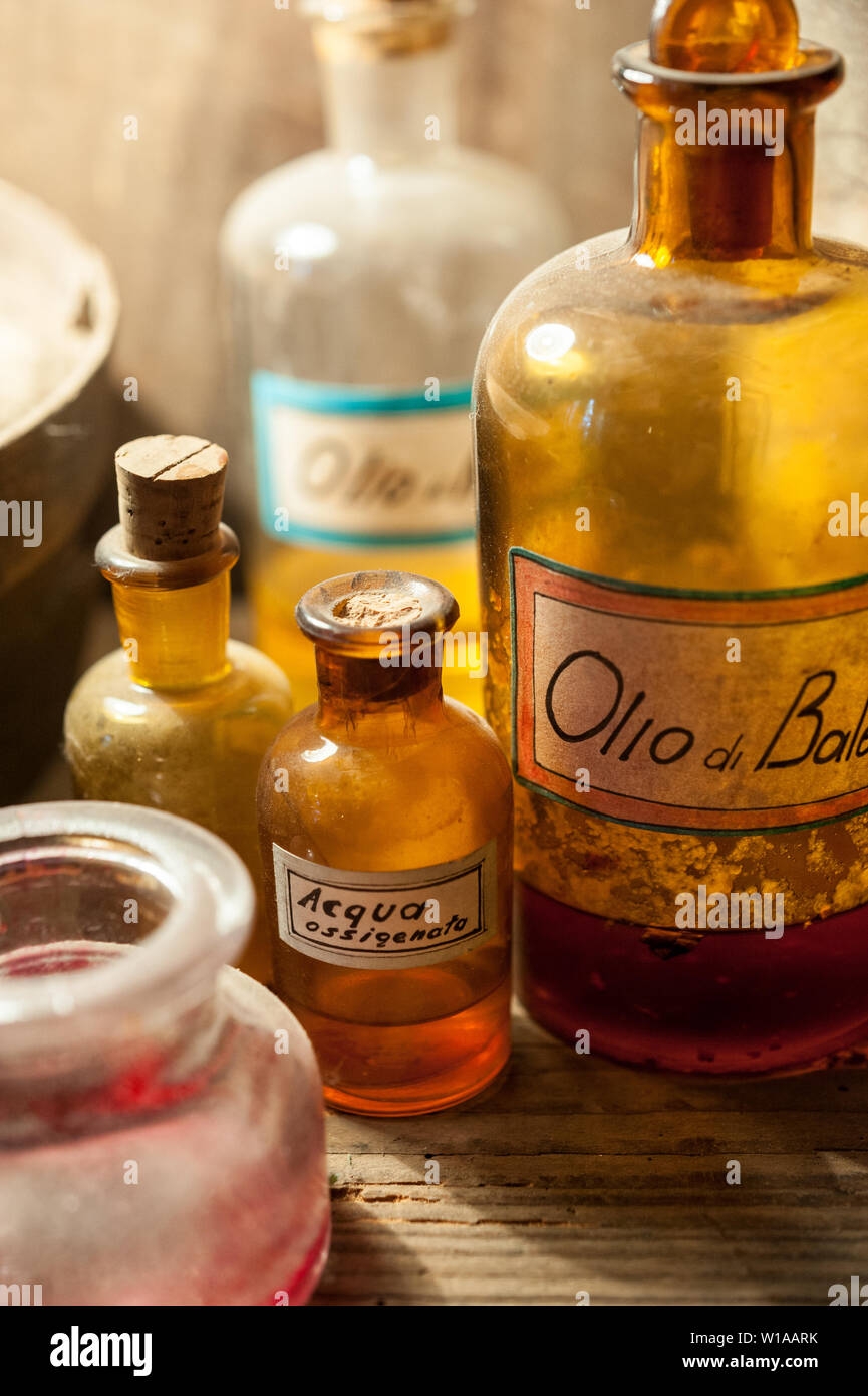 Alcuni vecchi vintage bottiglie colorate di varie estratto ed essenza: l'etichetta dice: olio di balena (quella grande); perossido di idrogeno (quello piccolo) Foto Stock