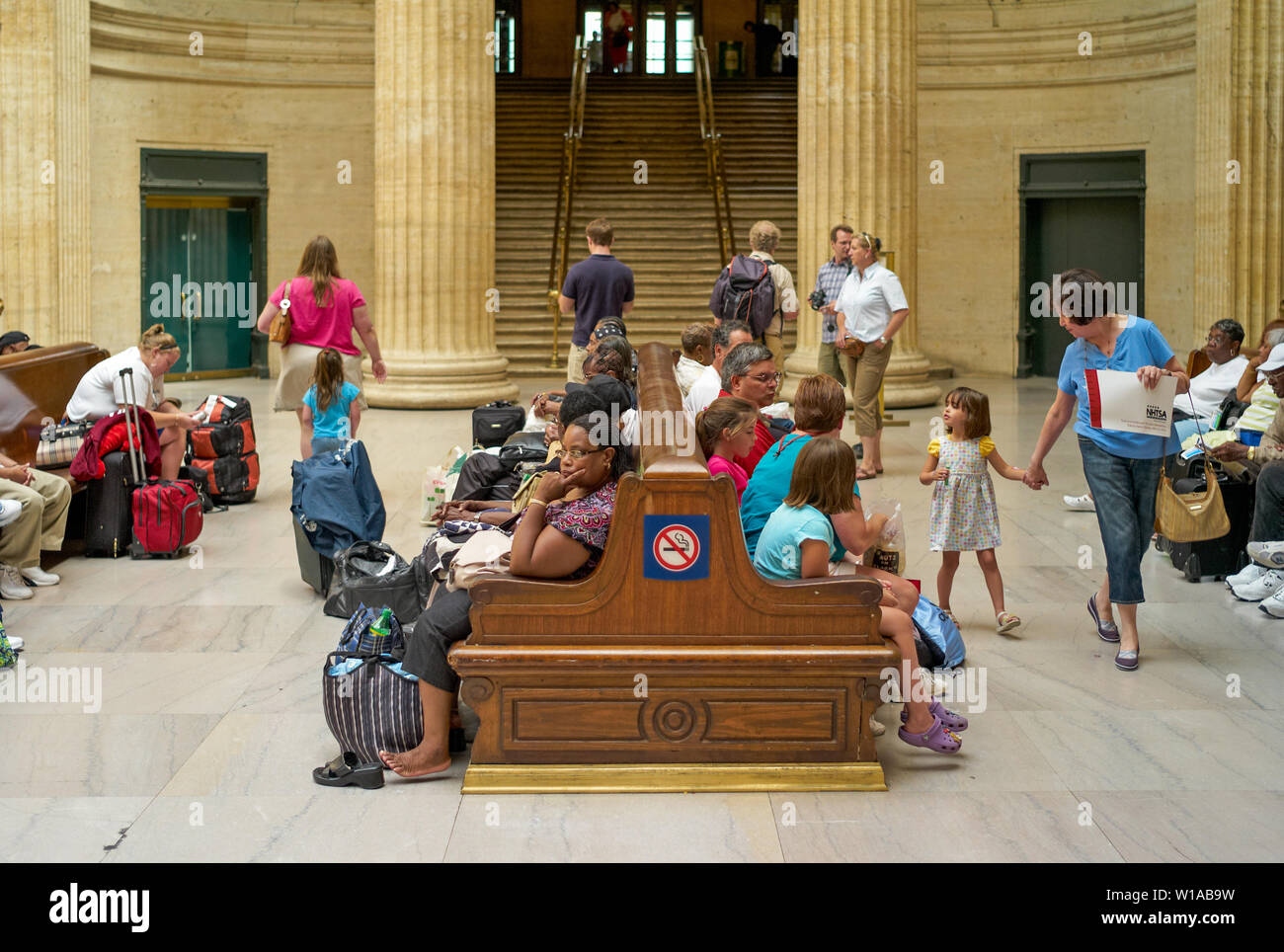 Chicago, Illinois, Stati Uniti d'America - 25 Luglio 2009: i viaggiatori in attesa sui banchi all'interno di Chicago Union Station con scalinata in background. Foto Stock