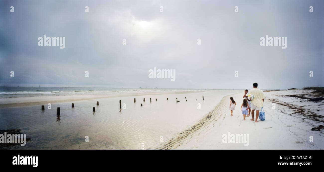 Famiglia camminando lungo la spiaggia Foto Stock