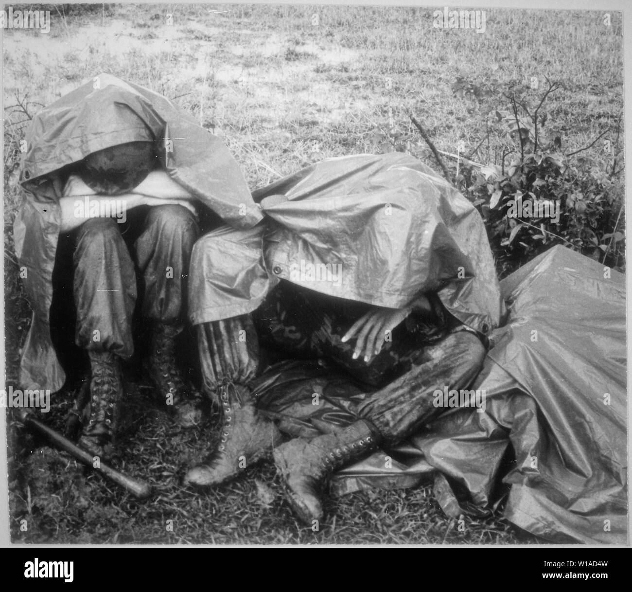 Una pausa nella pioggia--due battaglia Leathernecks stanchi del XXVI Reggimento Marine prendere una pausa, pioggia e tutti, durante il funzionamento Bold Mariner. Il funzionamento di cordon sulla penisola di Batangan di Quang Ngai provincia è finalizzata a scoprire e distruggere la temuta Viet Cong e la sua politica di infrastruttura che prede su indifesi vietnamita in remoti villaggi e borghi. Foto Stock