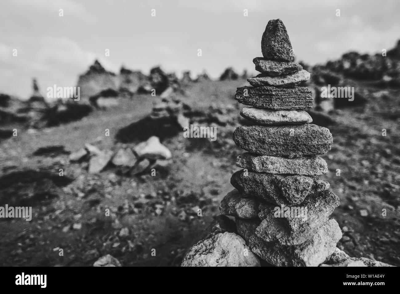 Torre di rocce sulla spiaggia. Zen di piccole dimensioni al di fuori della pila di pietre sulla roccia. Tombe dei Re, un'antica necropoli a Paphos, Cipro, B&W Foto Stock