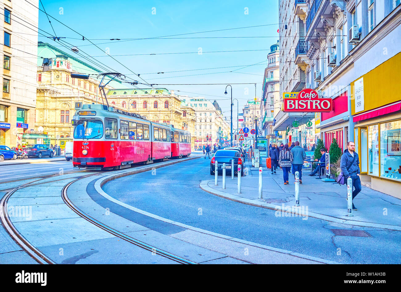VIENNA, Austria - 18 febbraio 2019: La scena urbana con il rosso in stile retrò il tram passa lungo la central Karntner Strasse con Opera di Stato di Vienna sul Foto Stock