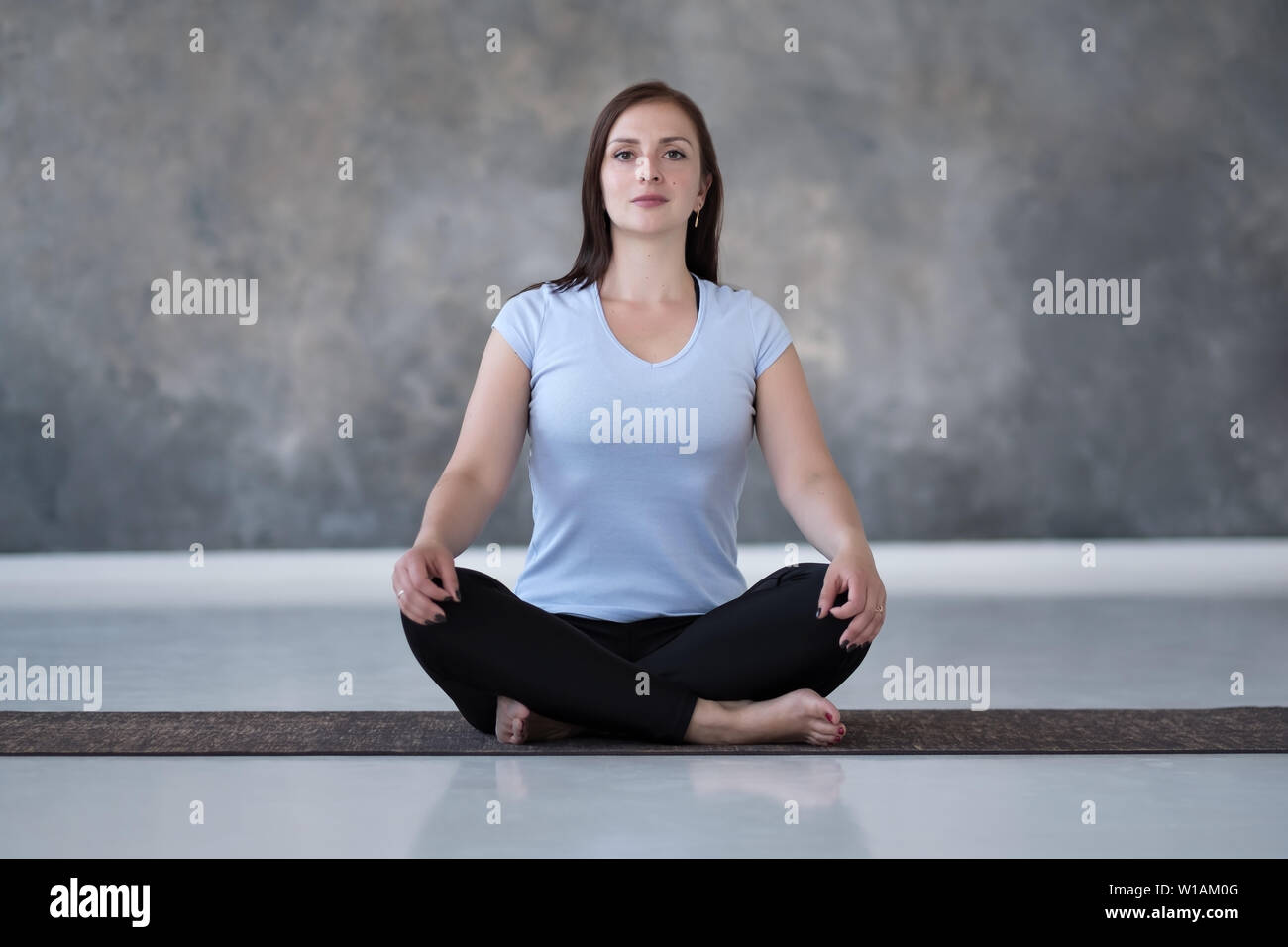 Donna pratica lo yoga, facendo esercizio Sukhasana, facile posa del sedile Foto Stock