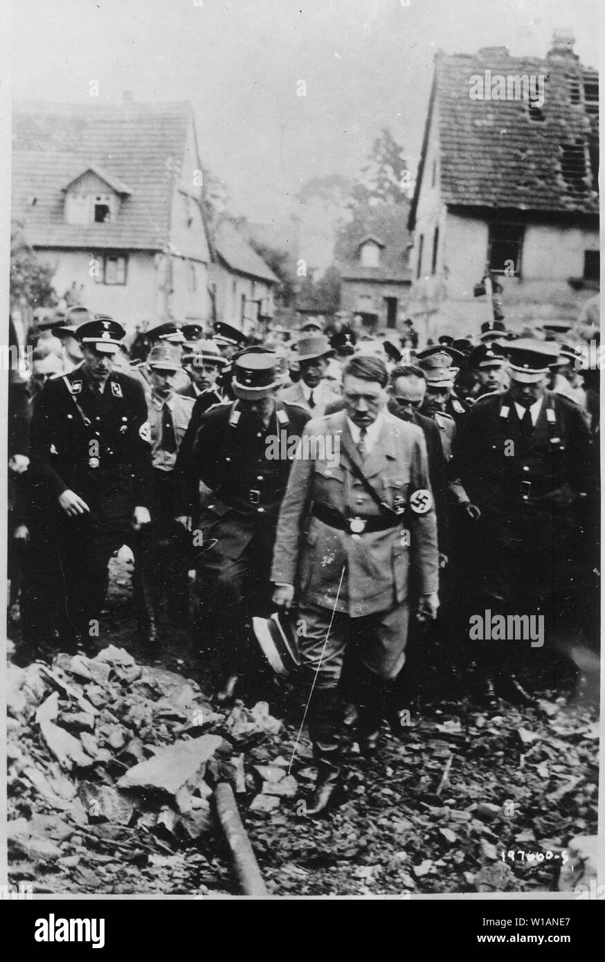 Adolf Hitler, accompagnato da altri funzionari tedeschi, cupamente ispeziona i danni della bomba in una città tedesca nel 1944, in questo film tedesco catturato da parte del governo degli STATI UNITI Army Signal Corps sul fronte occidentale.; inglese: il telaio ancora dal film rappresenta Adolf Hitler a piedi attraverso le rovine di Öschelbronn il 14 settembre 1933. Il 10 settembre 1933 un incendio distrusse 184 edifici danneggiati e 111 strutture, risultante in 357 fuori del 1421 i residenti di diventare senzatetto. Hitler è arrivato in Öschelbronn intorno a 13:45 e a sinistra per Böblingen intorno a 14:30. L'immagine è stata utilizzata a fini di propaganda da parte dei tedeschi.[1][2][3 Foto Stock