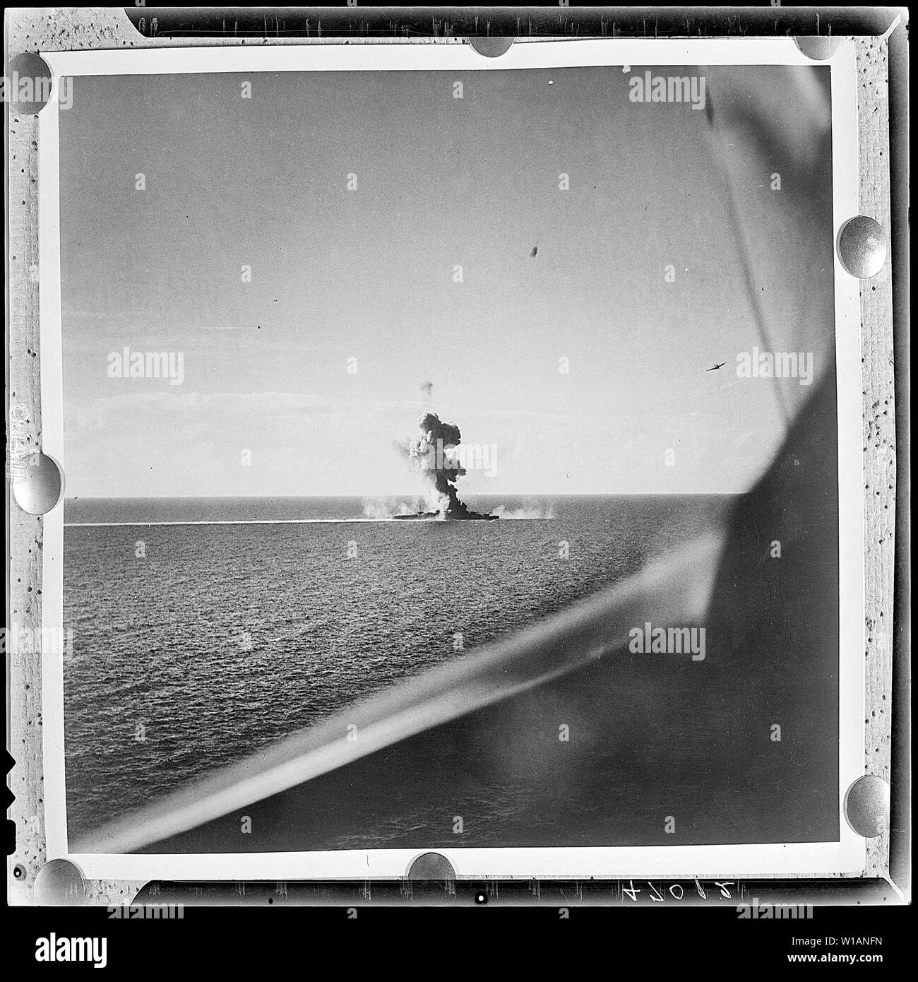 Antenna dell'invasione americana di Engebi isola in Eniwetok atollo. Flares (sinistra) segnale della flotta per il bombardamento di sollevamento in modo che landing craft può grembiale per spiagge.; note generali: La descrizione è ovviamente sbagliato. La foto mostra una nave da guerra giapponese (un cruiser?) sotto attacco: un giapponese Mogami-class cruiser sotto attacco da parte degli Stati Uniti Navy di Carrier aria Gruppo 7 (CVG-7) in seguito alla battaglia di Leyte Golfo, 26 ottobre 1944. Un Curtiss SB2C-3 Helldiver di bombardamenti Squadron 7 (VB-7) è visibile in alto a destra della fotografia. La cruiser è più probabilmente Kumano che aveva la prua è stata soffiata da un siluro l Foto Stock