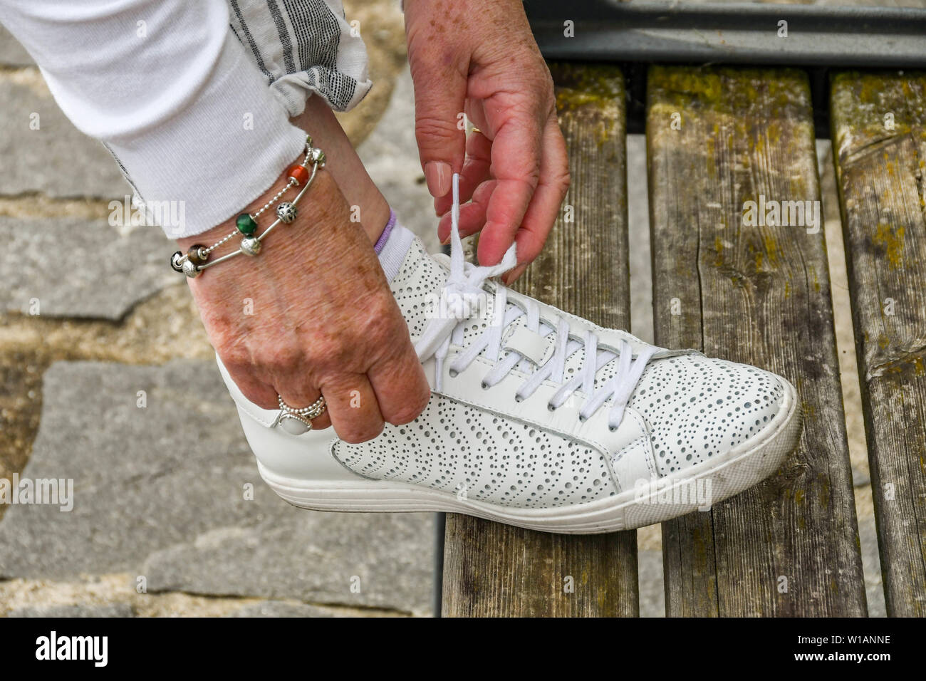 Il LAGO DI COMO, Italia - Giugno 2019: Close up di una persona di vincolare il suo stringa mentre si cammina sul sentiero che corre per diversi chilometri intorno al lago di Como - TH Foto Stock