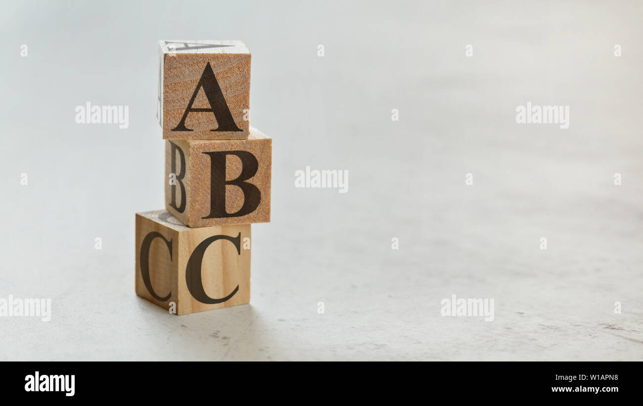 Palo con tre cubi di legno - lettere ABC su di essi, spazio per più di testo / immagini sul lato destro. Foto Stock