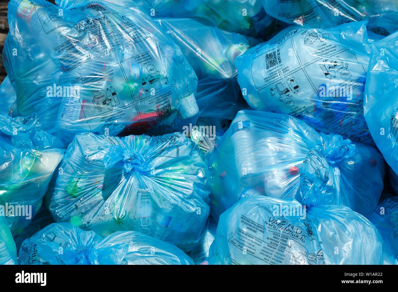 Pieno di luce blu sacchi della spazzatura con immondizia di plastica su uno heap, Lussemburgo Foto Stock