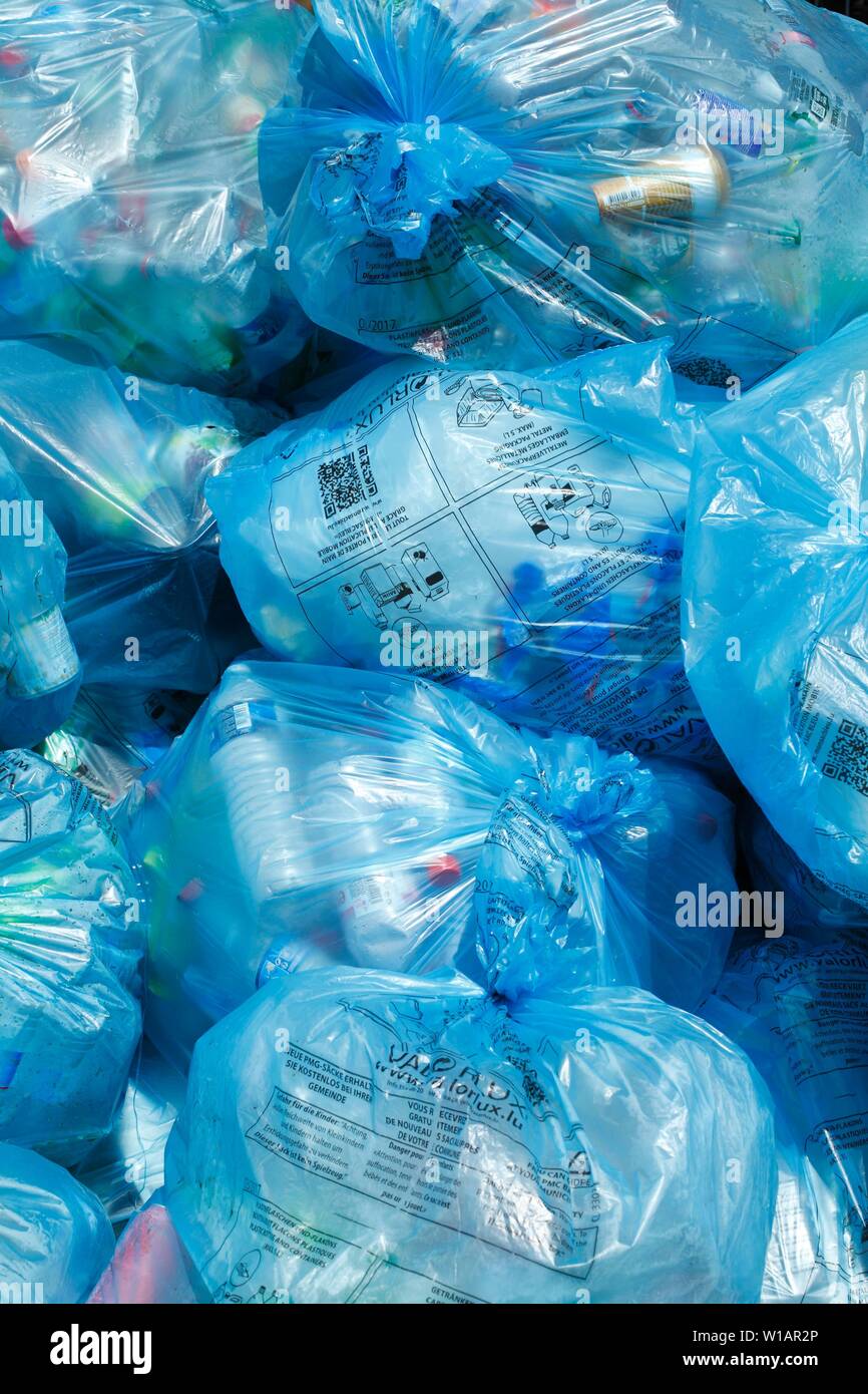 Pieno di luce blu sacchi della spazzatura con immondizia di plastica su uno heap, Lussemburgo Foto Stock