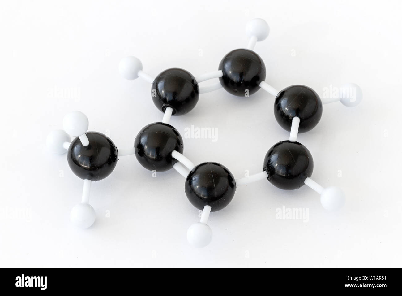 Modello a sfera e bastone di plastica di una molecola di toluene o metilbenzene (C7H8), mostrato con struttura a chekule su sfondo bianco. Gruppo metile rimasto. Foto Stock