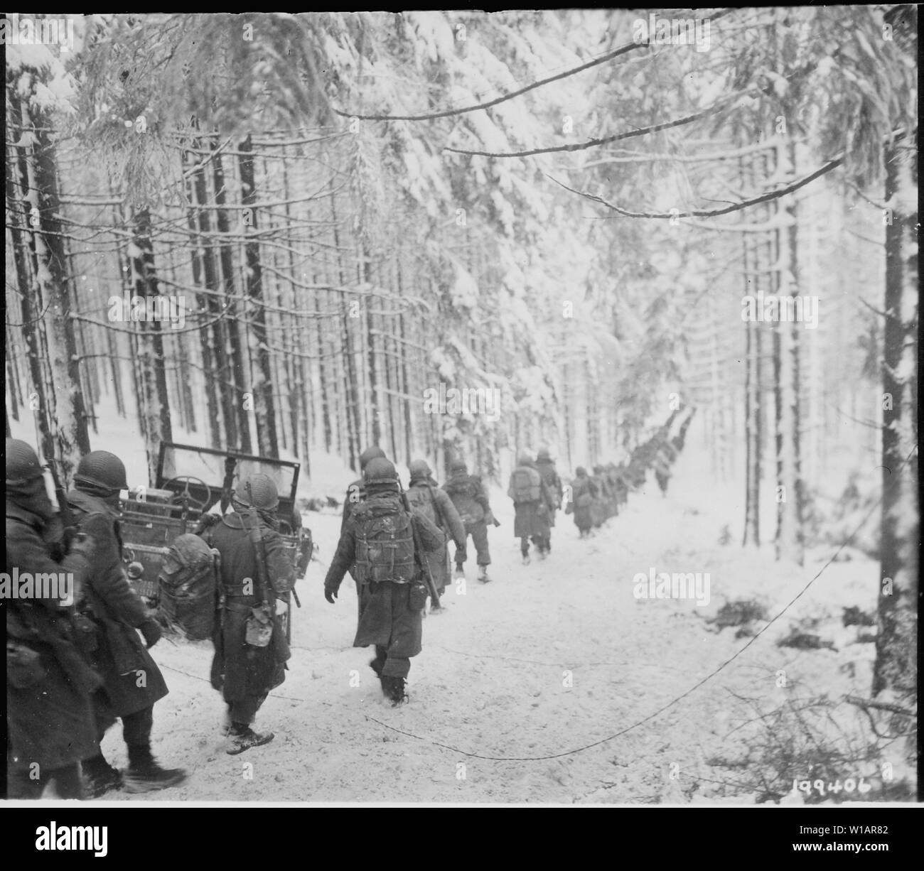 I soldati americani della 289a Reggimento di Fanteria marzo lungo la coperta di neve sulla strada il loro modo per tagliare la Saint Vith-Houffalize strada in Belgio.; Note Generali: Utilizzo di guerra e di conflitto numero 1079 quando si ordina una riproduzione o la richiesta di informazioni su questa immagine. Foto Stock
